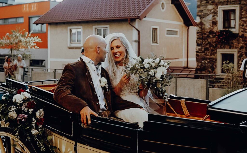 Pärchen in Hochzeitskutsche nach ihrer Heirat in St. Johann im Pongau